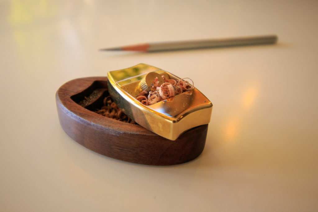 The Hovel pencil plane with its wooden stand, pencil shavings from sharpener