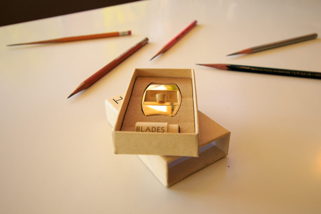 Hovel sharpener in fully recyclable box with blades, pencils surrounding box